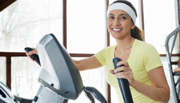 A woman doing exercise on a cardio machine in gym 