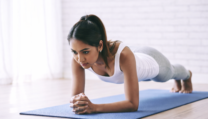 An adult girl performing plank exercise 