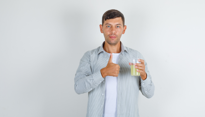 man holding lemon water in hand in morning