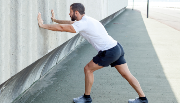 A person doing wall push ups hiit exercise 
