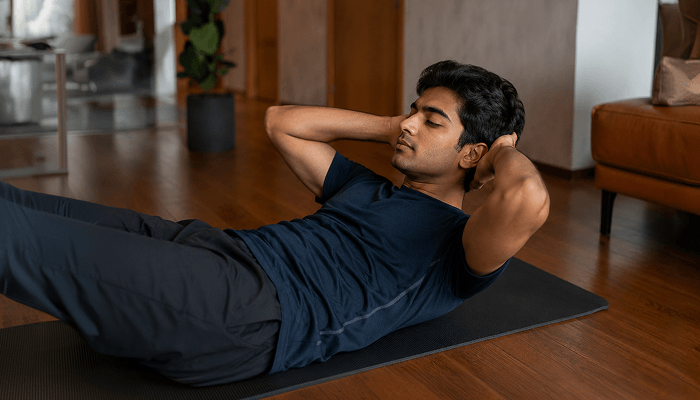 A man doing neck curl up exercise at home
