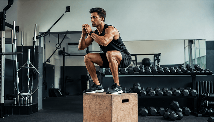 athletic man doing plyometic box jumps for functional training and strength