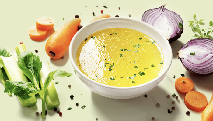 a bowl of vegetable soup broth made up of carrots and other vegetables to help patients going through refeeding syndrome or transitioning out of an intermittent fasting diet