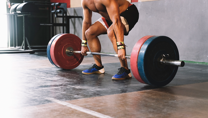 man at gym lifting weights for natural bodybuilding
